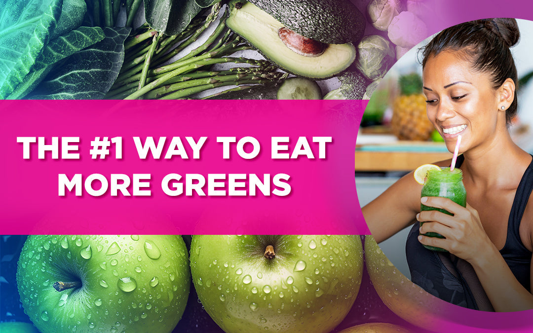 Woman drinking a green smoothie with fresh greens, apples, and avocado in the background.