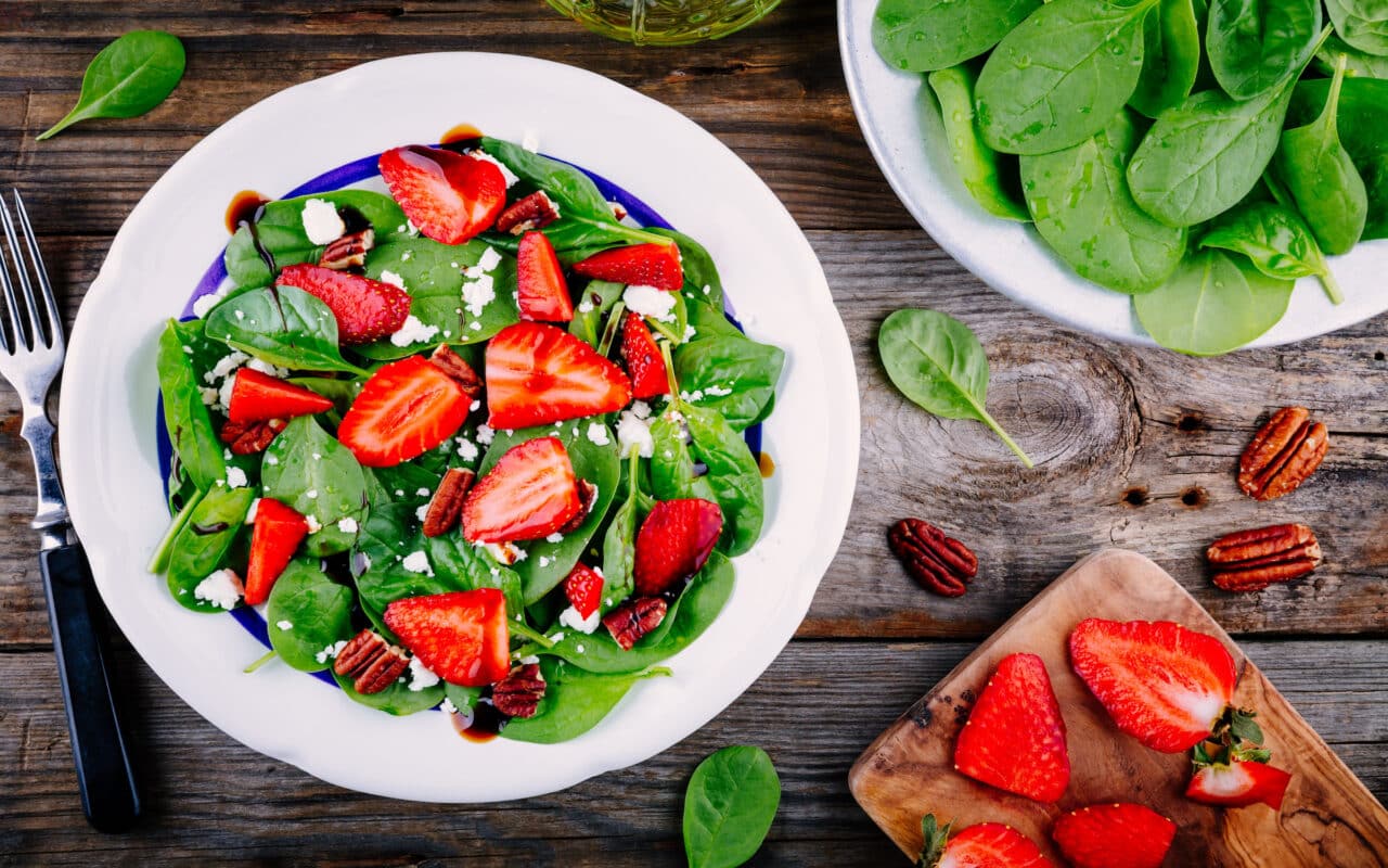 Spinach salad with strawberries, feta cheese, balsamic and pecan nuts