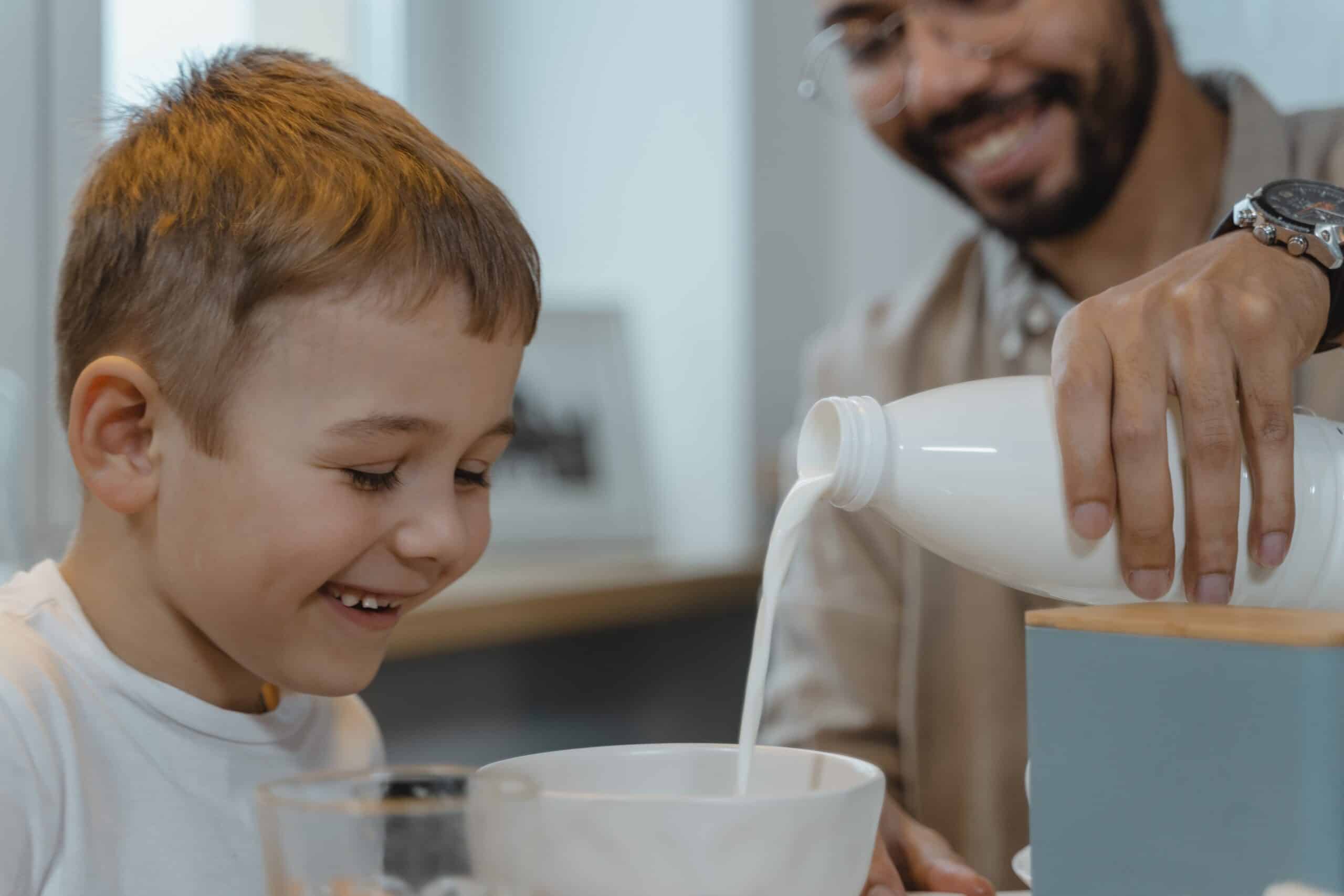 Man pouring milk into child's bowl