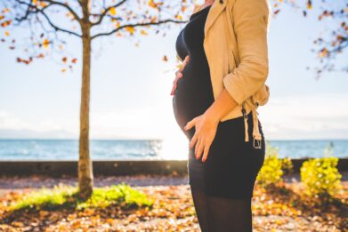 Woman standing outside with her bump showing